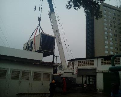 Crane lifting a generator beside the hotel facilities